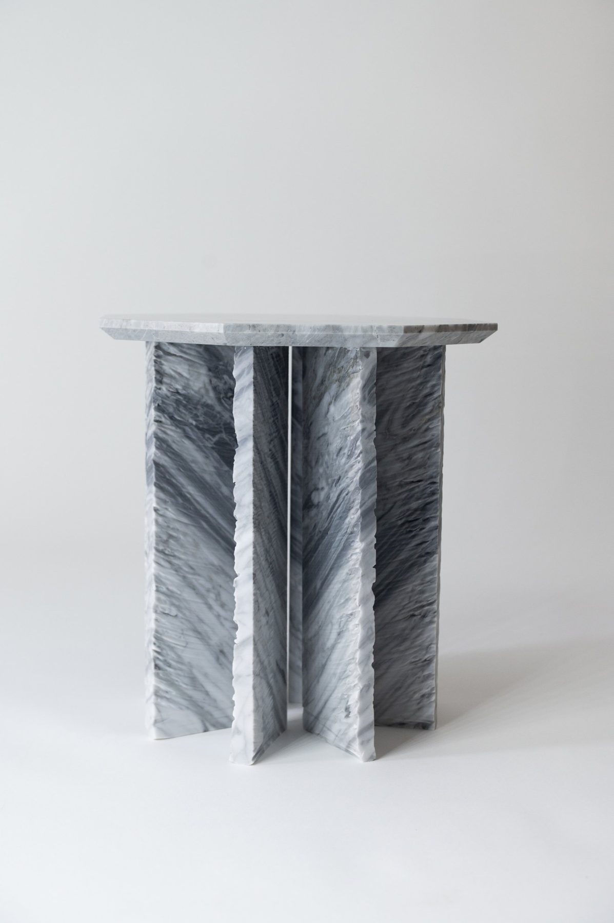 Un tavolino Wabi-Sabi intero, frontale, con la base a croce e il piano sottile